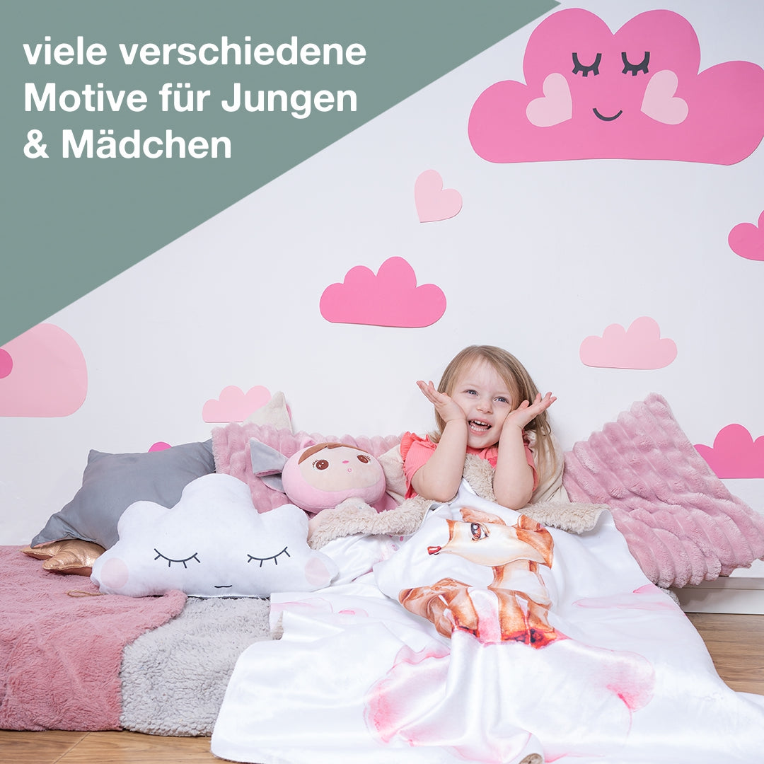 Kind freut sich über bestickte Babybdecke