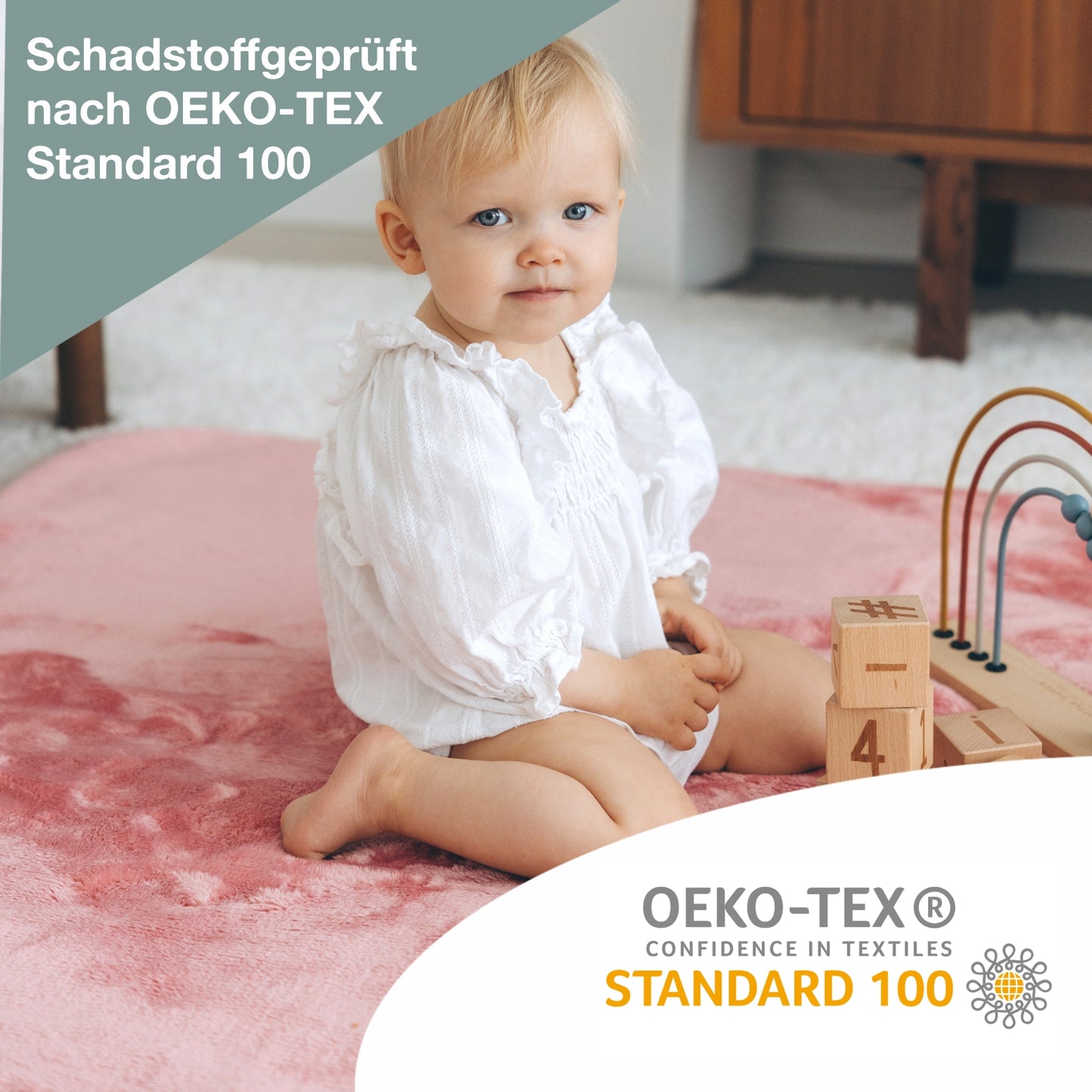 Mädchen spielt auf Boden und sitzt auf der Kuscheldecke