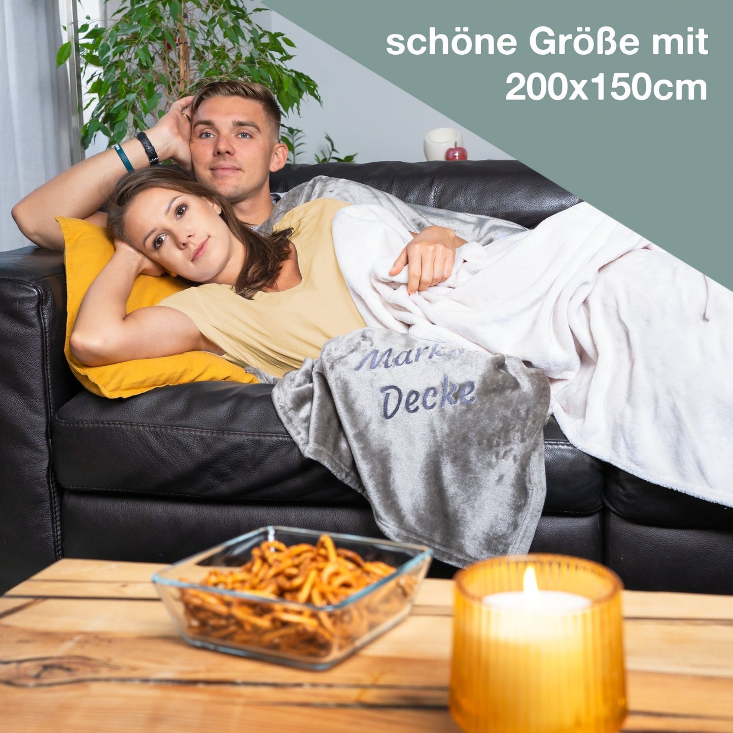 Pärchen liegt auf Sofa mit Wolimbo Wohndecke mit Namen bestickt