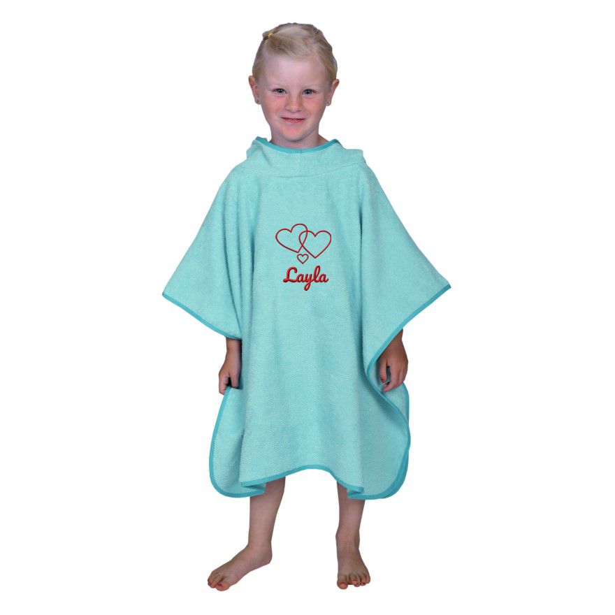 Kind trägt bestickten Badeponcho