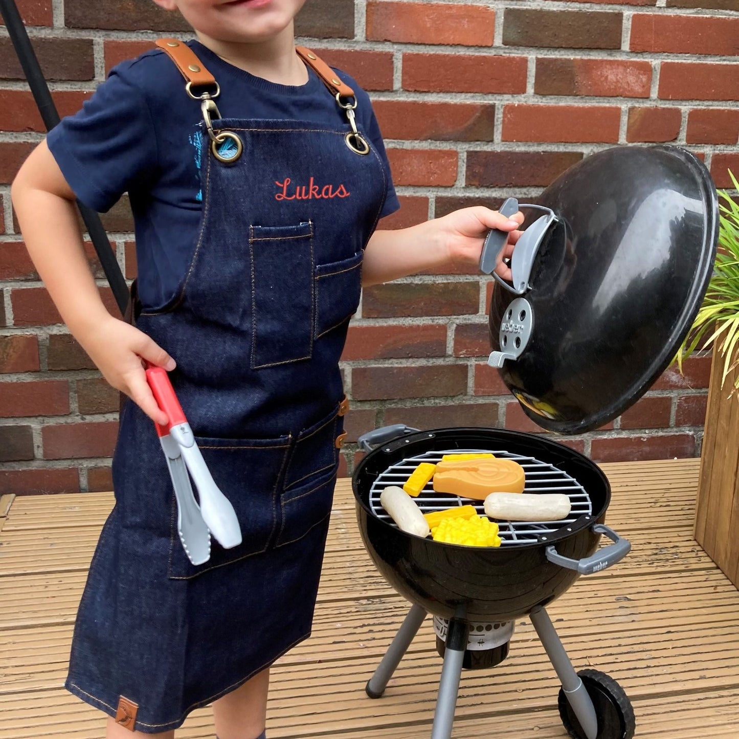 Junge mit Jeans Kinderschürze mit Namen Wolimbo