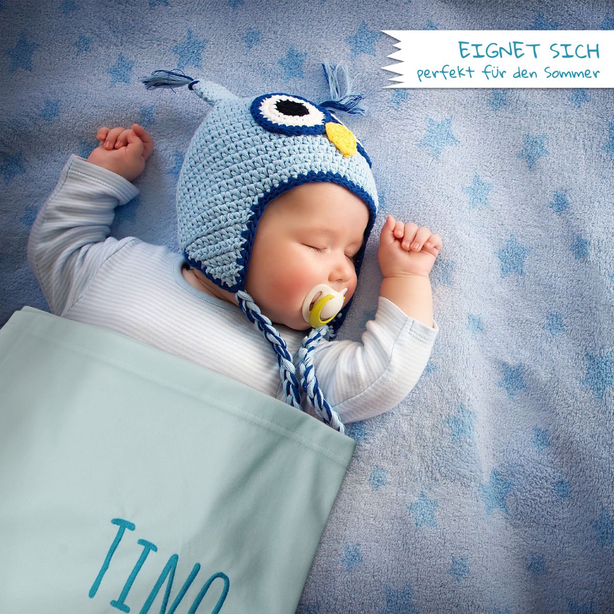 Baby eingewickelt in Babydecke mit Namen