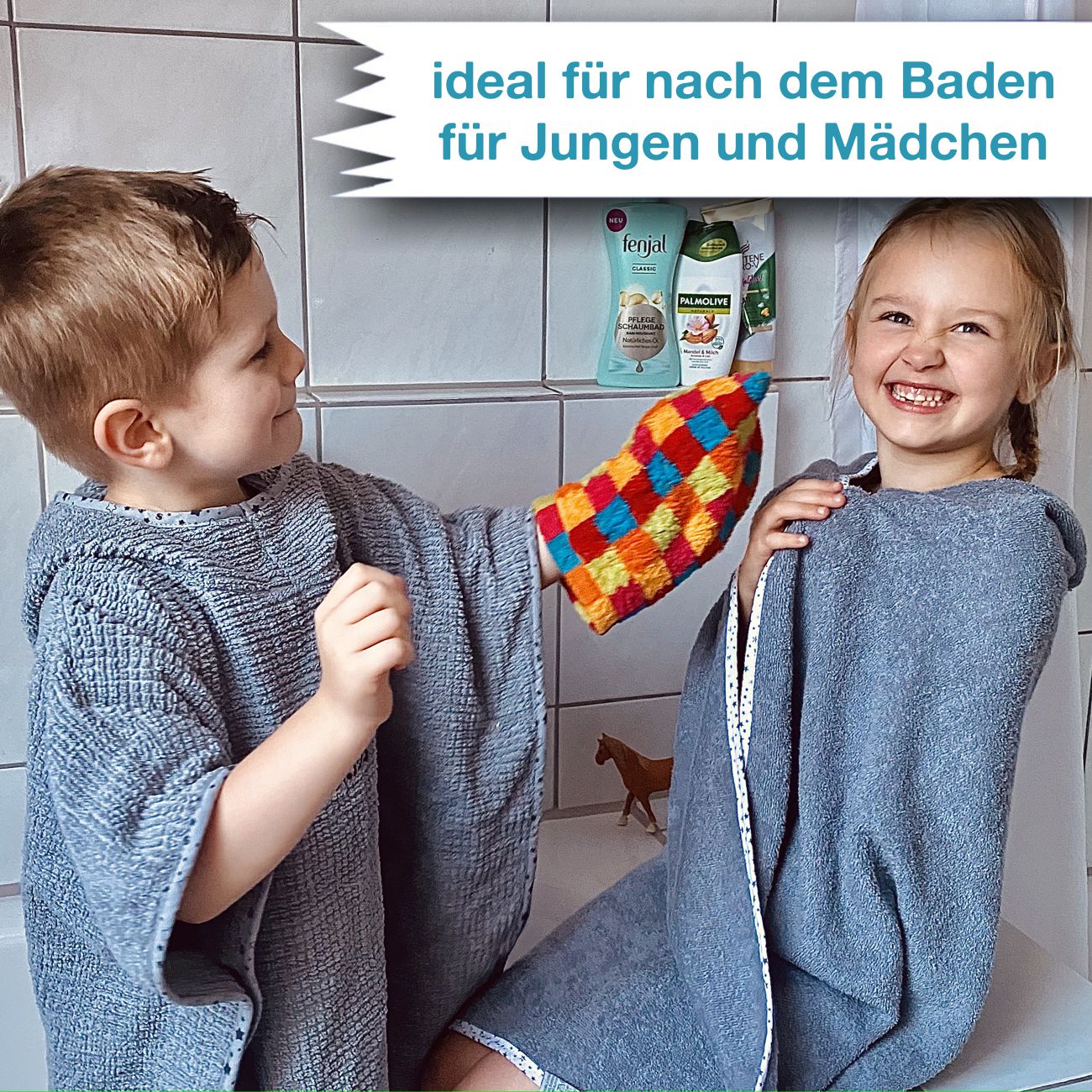 2 Kinder mit Poncho bestickt mit Namen in der Dusche