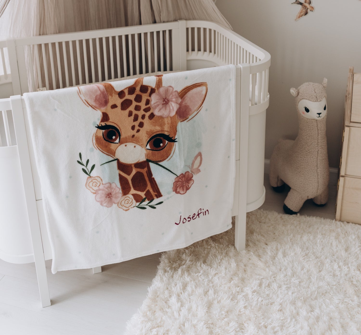Babydecken mit Namen Süsses Motiv über Babybettchen gelegt