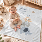 Baby sitzt auf personalisierter Babydecke mit Namen und Elefantenmotiv