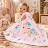 Mädchen kuschelt mit rosa Babydecke mit Schildkrötenmotiv im Kinderzimmer