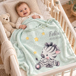 Personalisierte mintgrüne Babydecke mit Namen Felix und Zebramotiv, gemütlich im Babybett mit Baby.