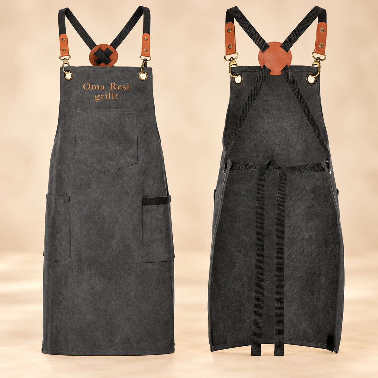 Personalisierte Grillschürze in Graphite mit Stickerei „Oma Resi grillt“ – Vorder- und Rückansicht mit gekreuzten Trägern und Lederimitat-Manschetten.