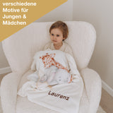 Junge auf Sessel mit individuell bestickter Babydecke