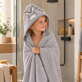 Kind nach dem Baden im grauen Kapuzenhandtuch mit Eselmotiv und Namensstickerei Karl