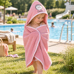 Kind im rosa Kapuzenhandtuch mit Igelmotiv am Freibad