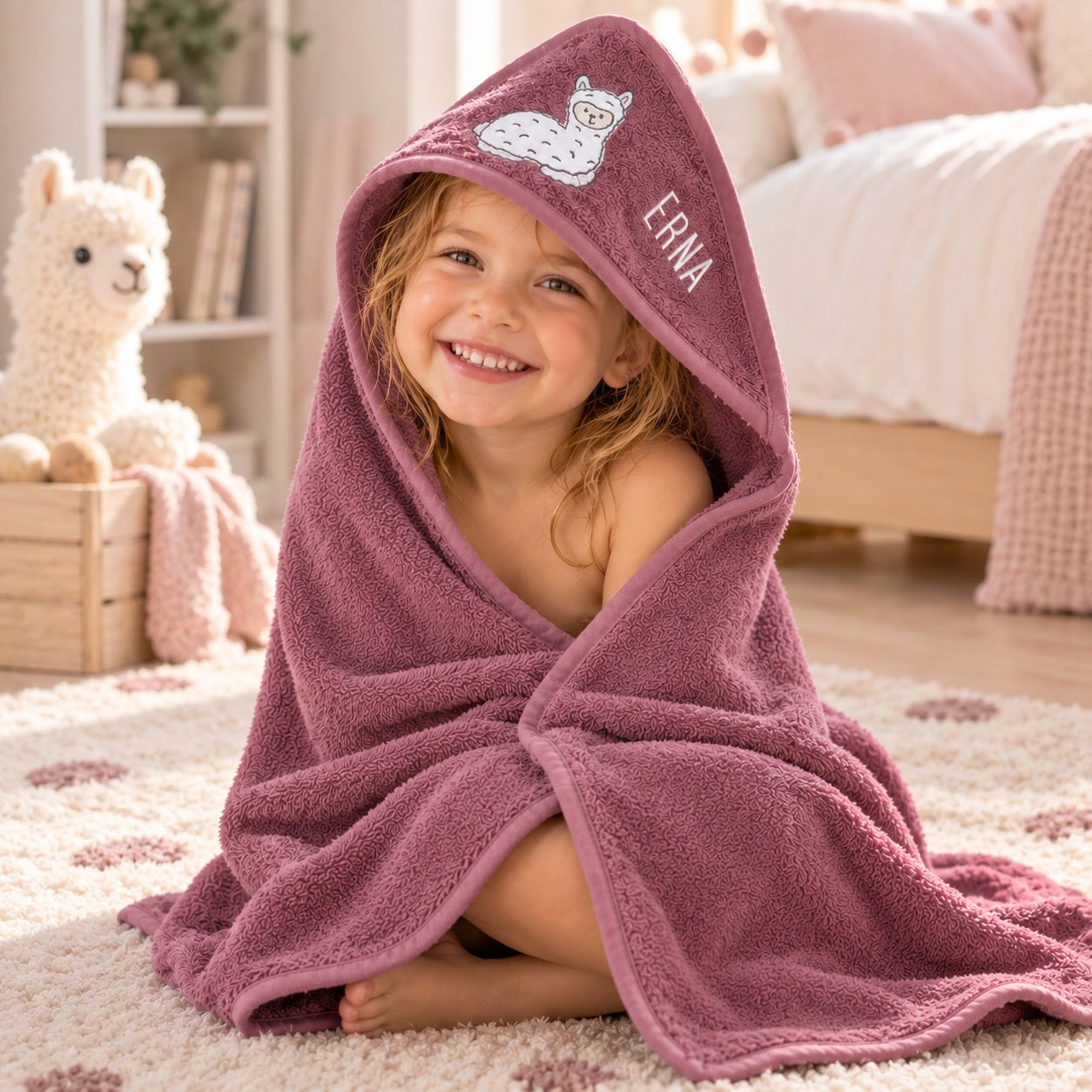 Kind mit personalisiertem Kapuzenhandtuch in Mauve mit Lamamotiv und Namensstickerei