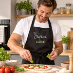 Personalisierte schwarze Kochschürze mit Namen Lukas und Chefkoch-Motiv beim Pizzabacken
