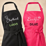 Personalisierte Kochschürzen in Schwarz und Pink mit gestickten Motiven Chefkoch und Backfee sowie den Namen Lukas und Silke