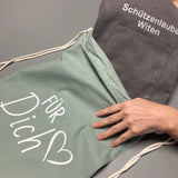 Beispiel Mitarbeiterin verpackt Schürze in Geschenkbeutel für dich von wolimbo