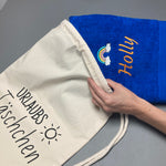 Beispiel personalisiertes Handtuch wird im Geschenkbeutel Urlaubstäschchen gepackt von wolimbo