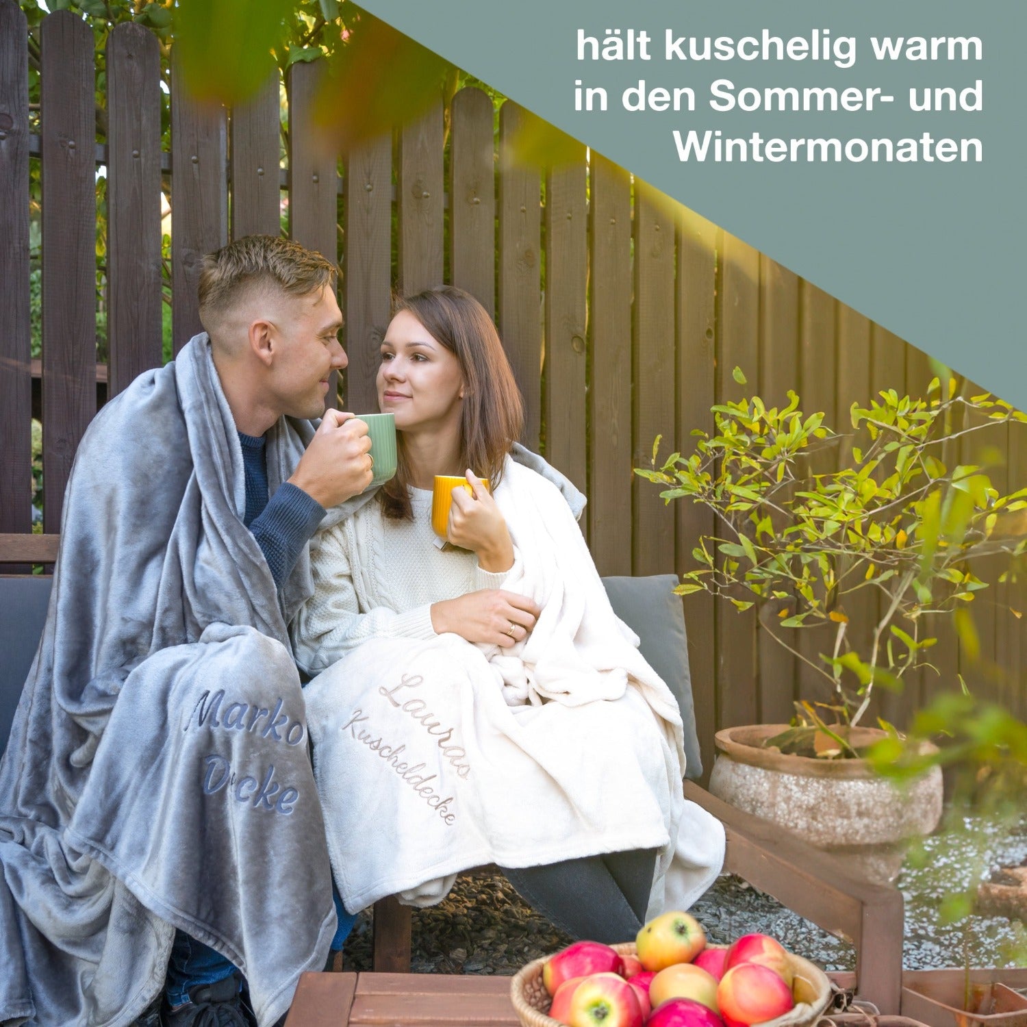 Pärchen sitzt im Garten mit Kuscheldecke mit Namen bestickt von wolimbo