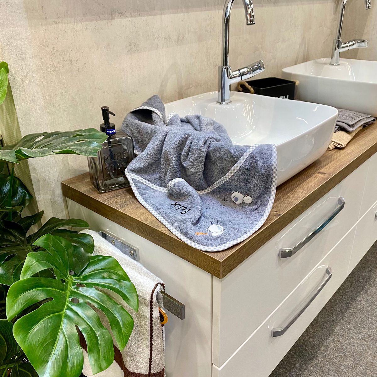 BIO-Handtuch Küken grau liegt auf Waschbecken