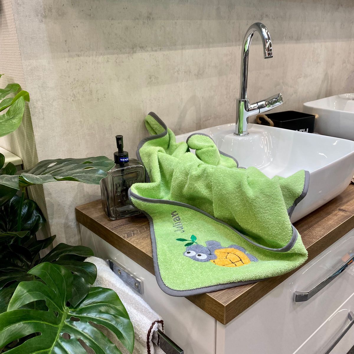 BIO-Handtuch Schildkröte opalgrün liegt auf Waschbecken