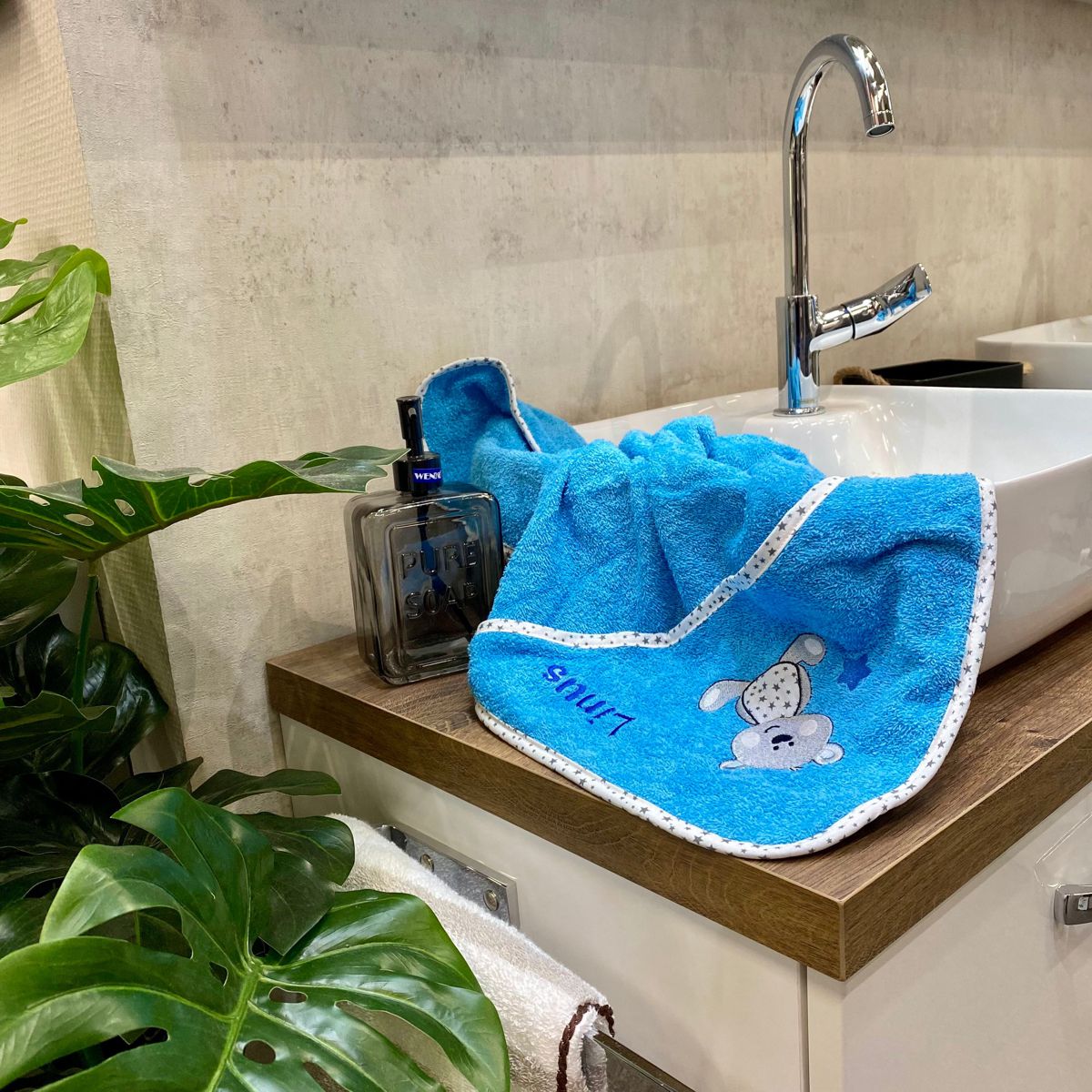 Handtuch Hund türkis liegt auf Waschbecken