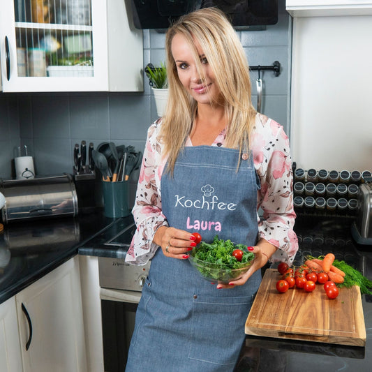 Frau in Küche mit Wolimbo Classic Denim Schürze bestickt mit Namen und Motiv