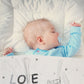 Kind schläft mit Babydecke mit Namen