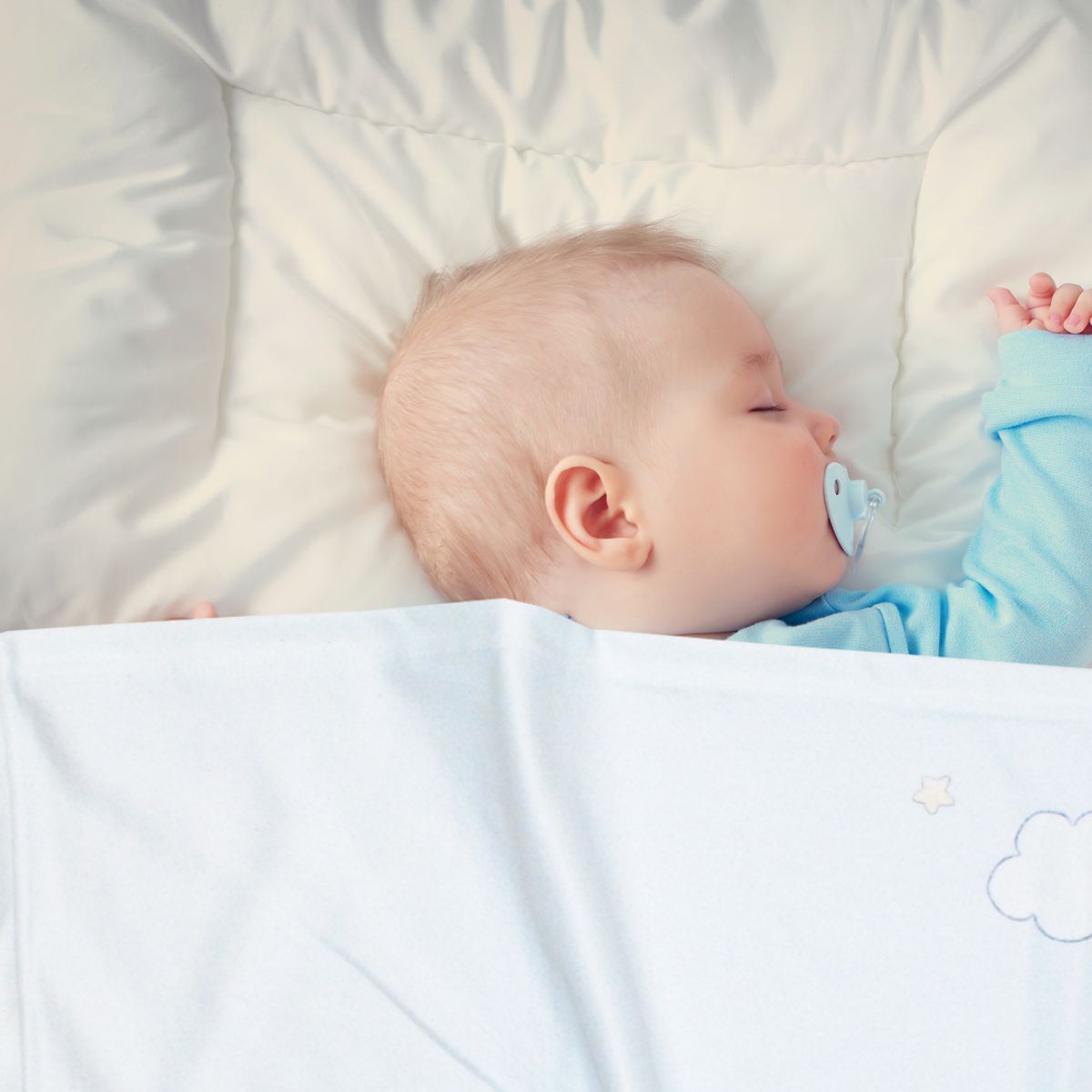 Baby schläft mit Decke mit Namen Waschbär
