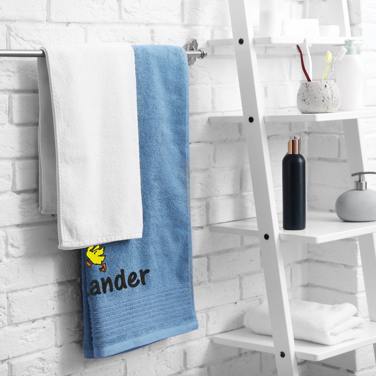 Handtuch mit Namen und Logo bestickt Wolimbo Beispiel Handtuch im Badezimmer am Haken