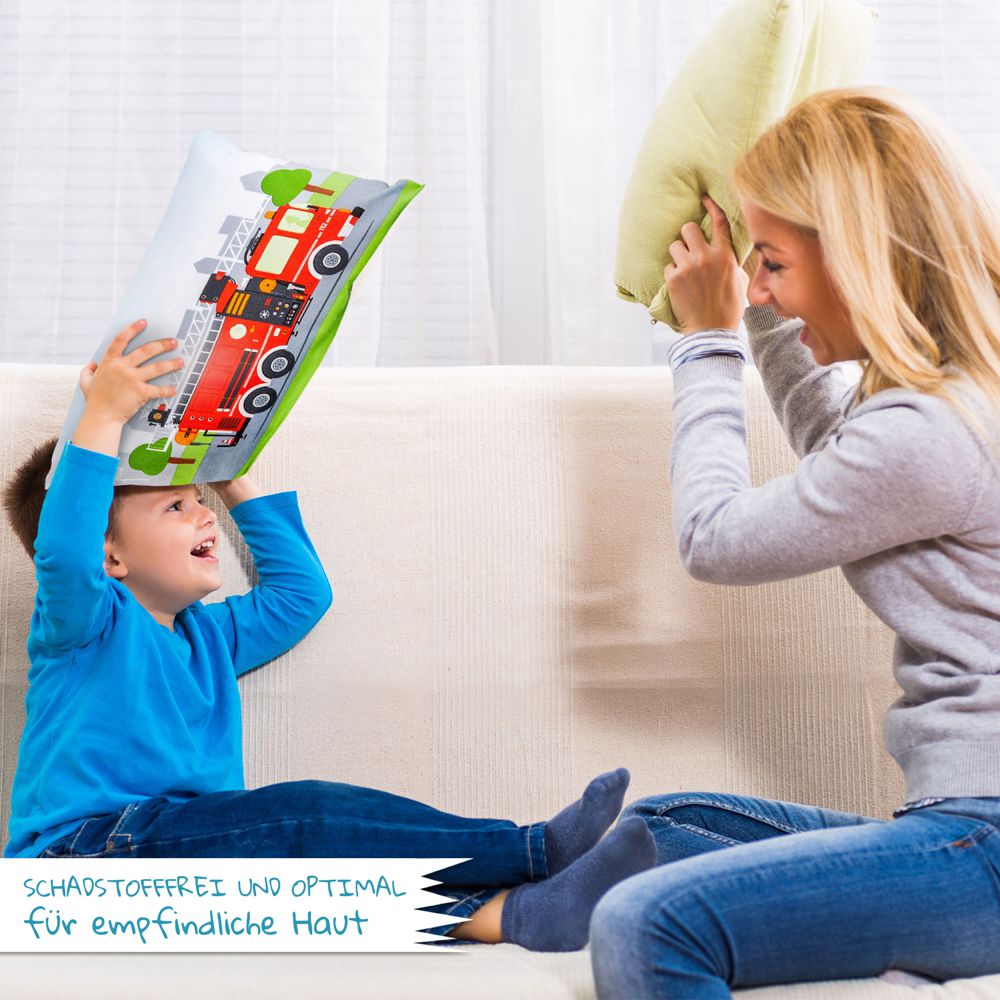 Mutter und Kind spielen mit Kinderbettwäsche